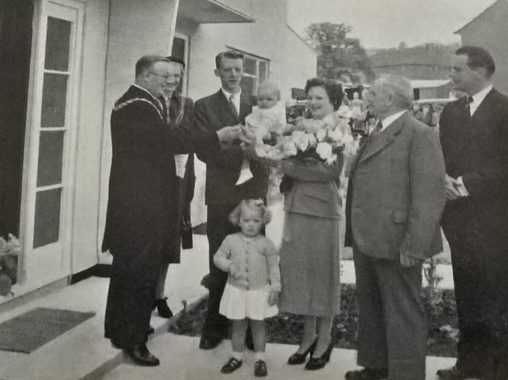 Family being presented with key to new home