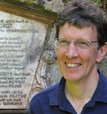 Colin Burrow standing in front of plaque